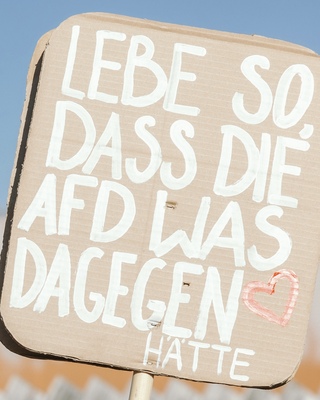 Demoschild mit der Aufschrift: Lebe so, dass die AfD was dagegen haette