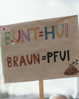 Demoschild mit der Aufschrift: Bunt=HUI Braun=Pfui